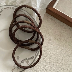 Detailed view of high-elastic leopard print hair bands on a vintage porcelain plate