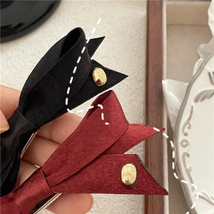 Gros plan détaillé de barrettes nœuds en velours mat avec boucles en métal doré