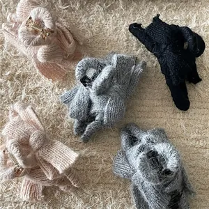 Knit bow hair claw clips for women in pink grey and black colors on plush background