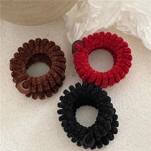 Vue détaillée de trois élastiques spirales en peluche avec des perles de couleur assortie