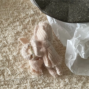 Close-up of a pink knitted bow hair claw clip showing soft yarn texture and metal spring
