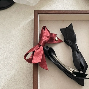 Gros plan de barrettes nœud en satin bordeaux et noir avec clips croco en métal argenté