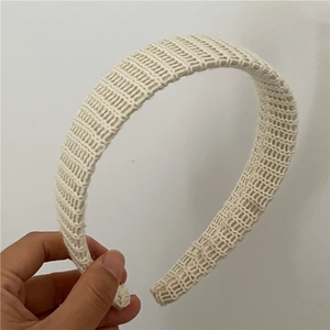 Gros plan d'un bandeau en maille ivoire avec texture côtelée verticale et tissu doux