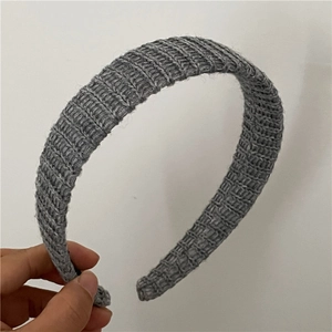 Détail de la texture en maille verticale sur un bandeau en laine gris foncé pour femmes