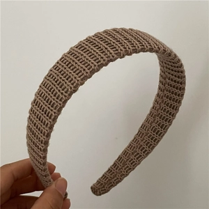 Vue détaillée de la texture en maille épaisse d'un bandeau d'hiver beige pour femme