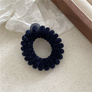 Gros plan sur l'élastique cheveux velours bleu foncé avec texture douce et boucle