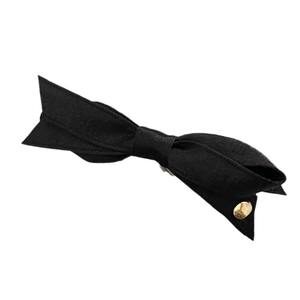 Barrette à cheveux élégante en satin noir avec nœud et bouton métallique doré sur fond blanc