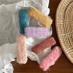 Gros plan de barrettes rectangulaires en maille colorée sur papier de soie blanc