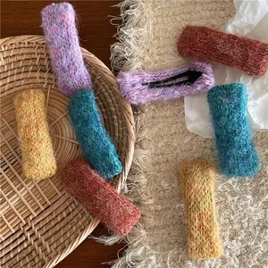 Barrettes BB rectangulaires en maille colorée violet jaune et bleu sur plateau rustique