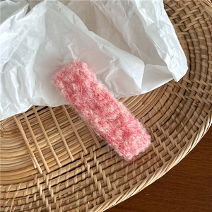 Gros plan sur la barrette rectangulaire en laine rose avec texture de tissu bouclé