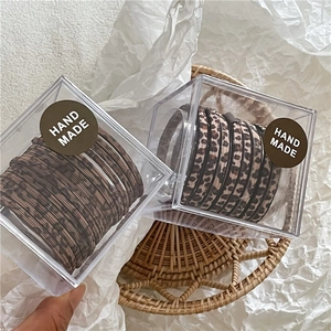 Dettaglio ravvicinato di elastici per capelli leopardati in confezione regalo trasparente