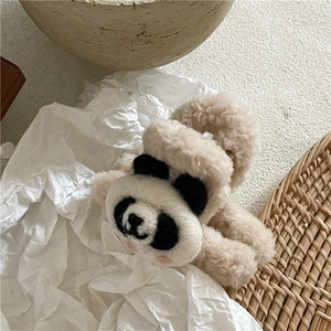 Detail shot of a soft beige plush dog hair claw clip with a cute cartoon face design