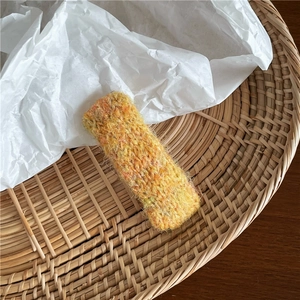Gros plan détaillé d'une pince à cheveux rectangulaire en laine tricotée multicolore