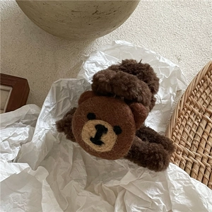 Detailed macro view of a brown plush hair scrunchie with a cute wool felt bear embellishment