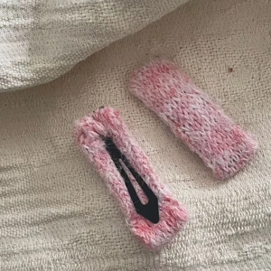 Détail des barrettes BB en laine tricotée rose et blanc avec texture douce faite main