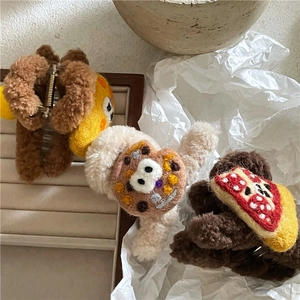 Drei süße Plüsch-Haarklammern mit Cartoon-Bär und Pizza-Motiven auf einem Holztablett