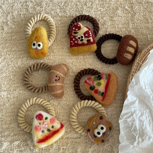 Detailed close-up of handmade felt food hair ties with pizza and bread designs