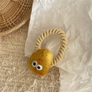 Detail of cute yellow wool felt chick hair tie on elastic beige spiral rope accessory
