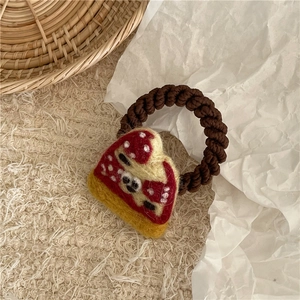 Close-up of handmade felt pizza hair tie with brown spiral elastic cord and cute mushroom design