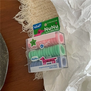 Detail van kleurrijke elastische haarbandjes in macaronkleuren in een transparante opbergdoos
