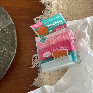 Detail van elastische haarelastiekjes in roze en muntgroen in heldere geschenkdozen