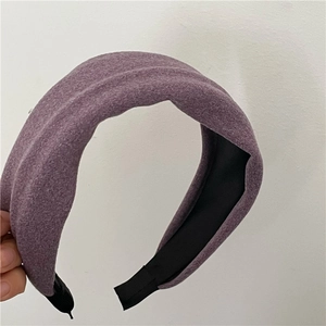 Close-up of wide padded headband in dark purple textured wool fabric with non-slip lining