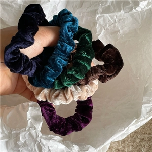 Close-up of velvet scrunchies in multiple colors showing soft fabric texture