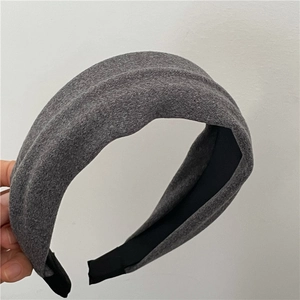 Detail of wide dark gray fabric headband with non-slip black inner lining