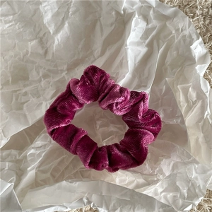 Detailed texture of deep rose velvet scrunchie showing soft fabric and elastic sheen