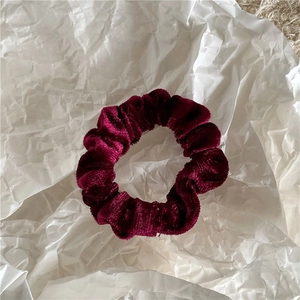 Detailed view of plush burgundy velvet scrunchie showing soft texture and rich sheen