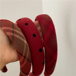 Three festive red padded headbands with plaid and polka dot patterns for women