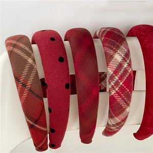 Close-up of assorted red festive headbands featuring plaid patterns and black polka dots