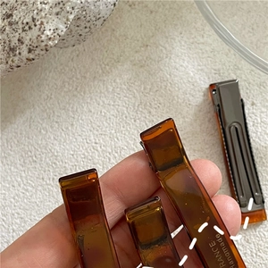 Macro view of handmade amber acetate hair clip with engraved France Handmade signature