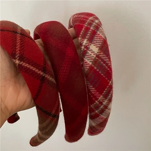 Close-up of three thick red plaid sponge headbands showing textured fabric and pattern