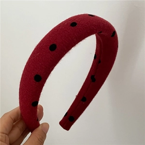 Side view of red sponge headband with black polka dots and soft velvet texture