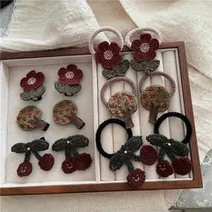 Handmade crochet floral and cherry hair accessories set in a vintage wooden box
