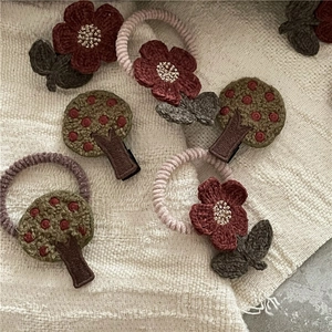 Detail of handmade knit floral hair tie and tree clip in vintage crochet style