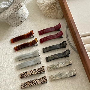 Detail shot of acetate geometric hair clips with marble patterns and France Handmade engraving