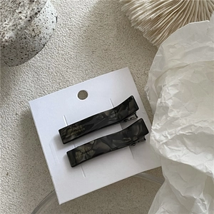 Detail of marble pattern acetate rectangle hair clips with gold handmade lettering