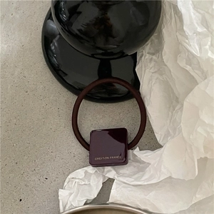 Détail de l'élastique à cheveux avec bloc carré violet foncé et texte Creation France