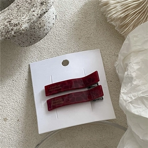 Detail of dark red tortoiseshell hair clips with gold France Handmade text on display card