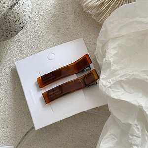 Detail view of two tortoiseshell acetate hair clips with France Handmade text on white card