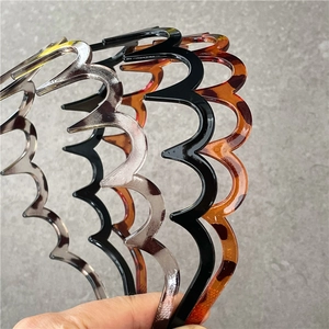 Three wave-shaped plastic headbands in black, grey, and tortoiseshell patterns for styling