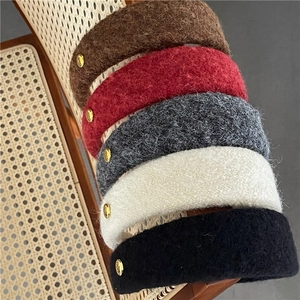Détail de serre-têtes en laine tricotée avec boucle dorée en couleurs automnales