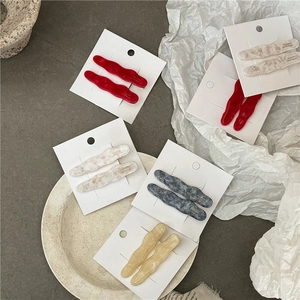 Lot de barrettes à cheveux ondulées en acétate coloré présentées sur carte blanche