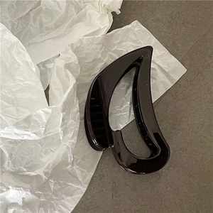 Detailed close-up of a large glossy brown hair claw clip with a hollowed curved design