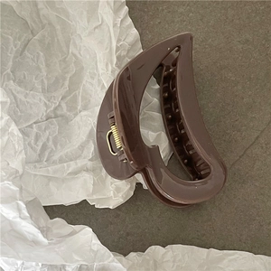 Close-up of a brown heart-shaped hair claw clip with glossy finish and metal spring