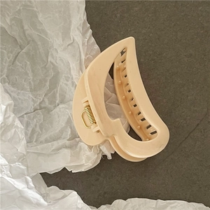 Detail of elegant hollow heart hair claw clip in apricot with a gold metal spring mechanism