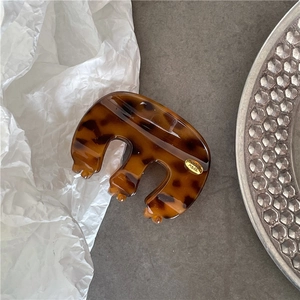 Détail de la pince à cheveux écaille de tortue avec logo métallique doré fait à la main