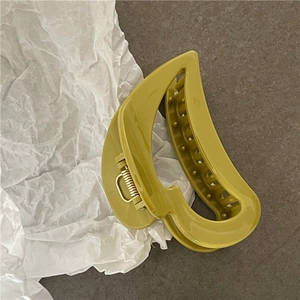 Detail of olive green hair claw clip with sturdy golden metal spring and inner teeth